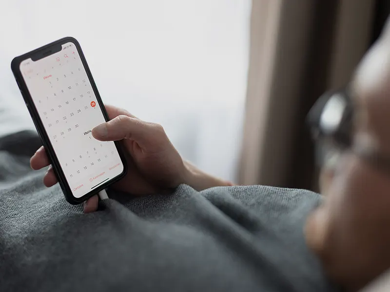 Un homme regarde un calendrier sur son smartphone